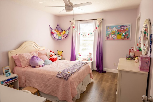 bedroom with ceiling fan, wood finished floors, and baseboards