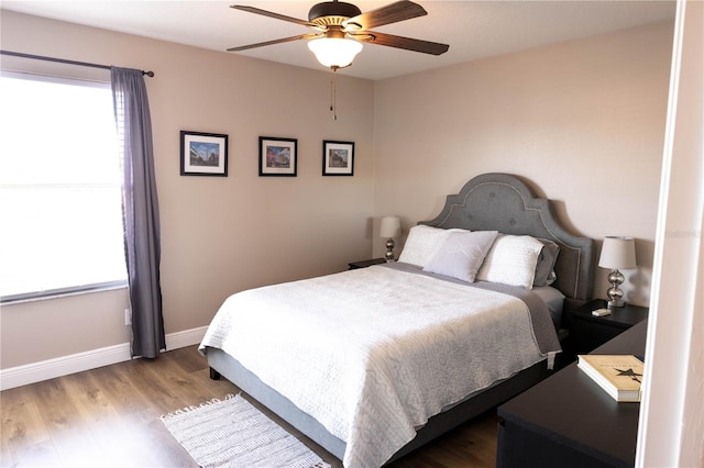 bedroom featuring ceiling fan, baseboards, and wood finished floors