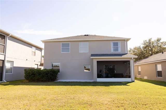 back of property featuring a lawn and stucco siding