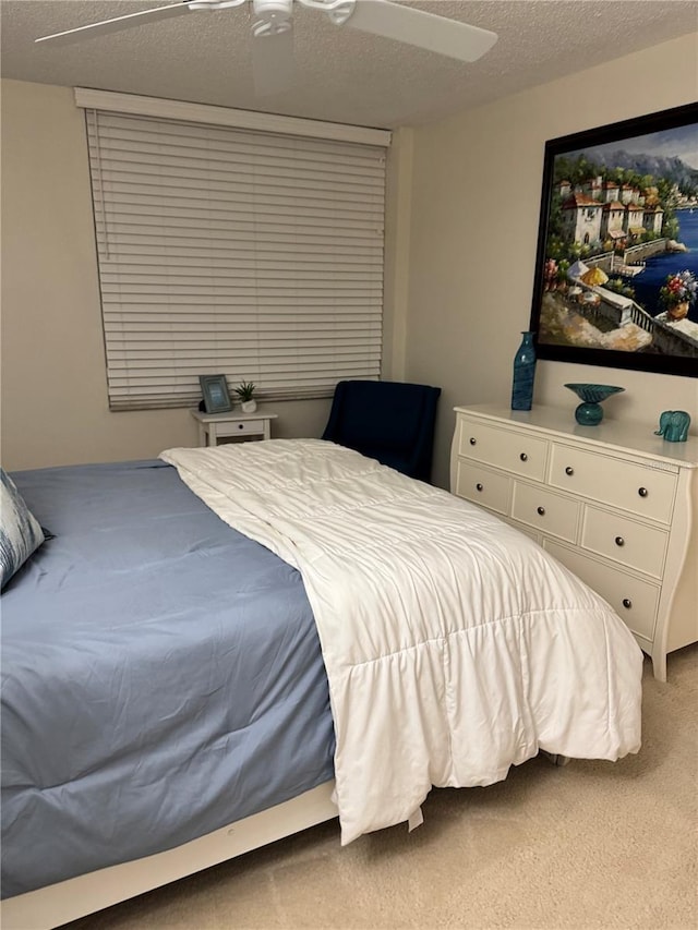 bedroom with a textured ceiling, ceiling fan, and carpet flooring