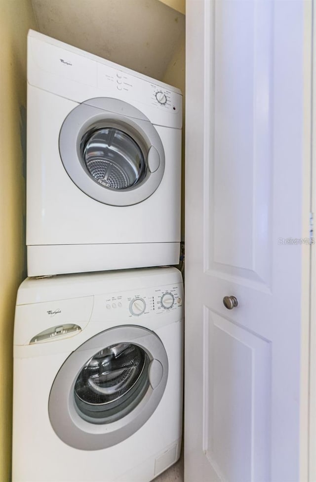 clothes washing area featuring stacked washer / drying machine and laundry area