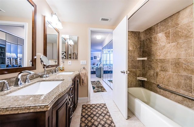 ensuite bathroom featuring tile patterned floors, a sink, visible vents, and connected bathroom