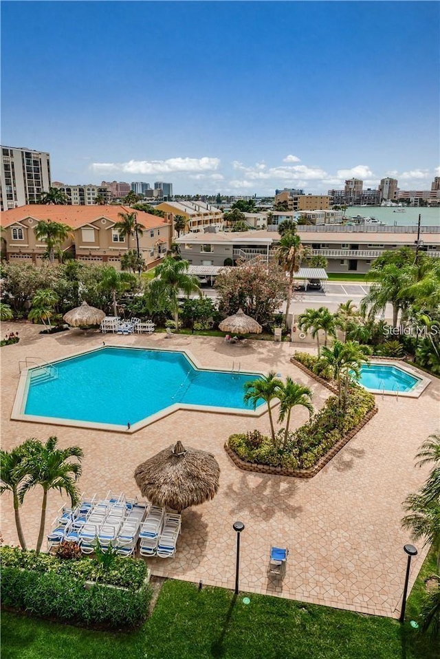 community pool with a city view and a patio