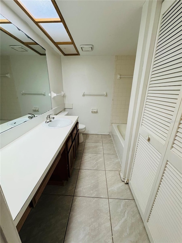 bathroom featuring vanity, toilet, a closet, and tile patterned flooring