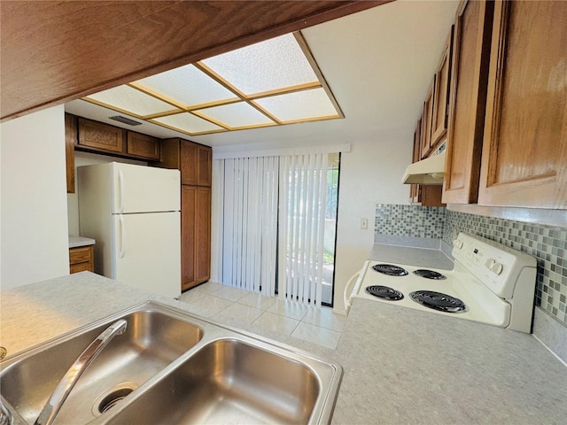 kitchen with visible vents, under cabinet range hood, backsplash, white appliances, and light countertops