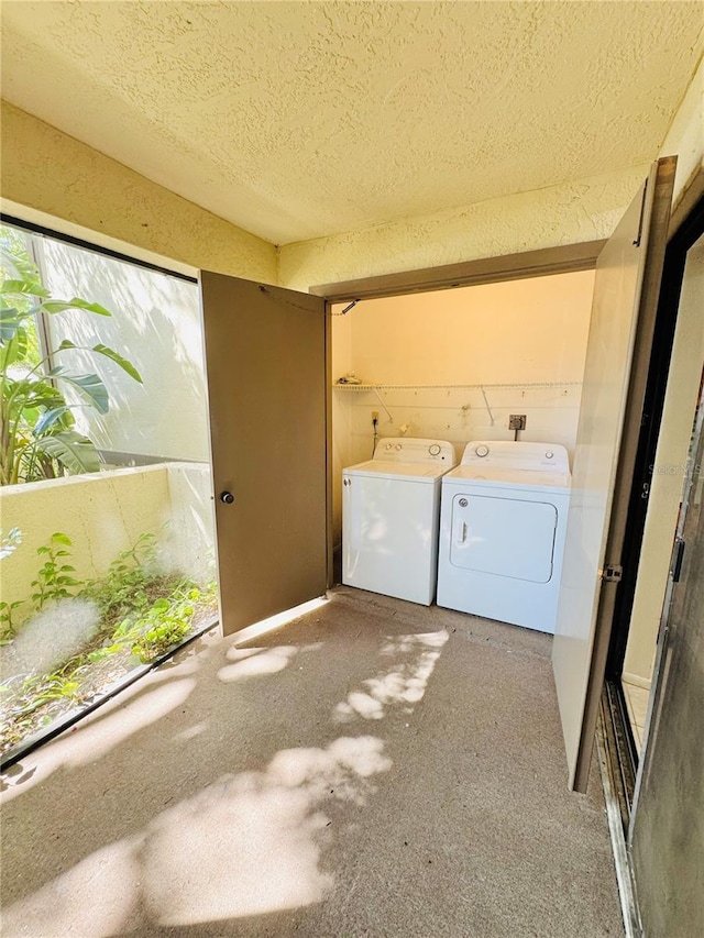 washroom featuring laundry area, separate washer and dryer, and a textured ceiling