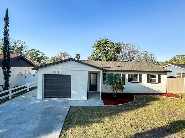 ranch-style home featuring a garage, a shingled roof, concrete driveway, fence, and a front lawn