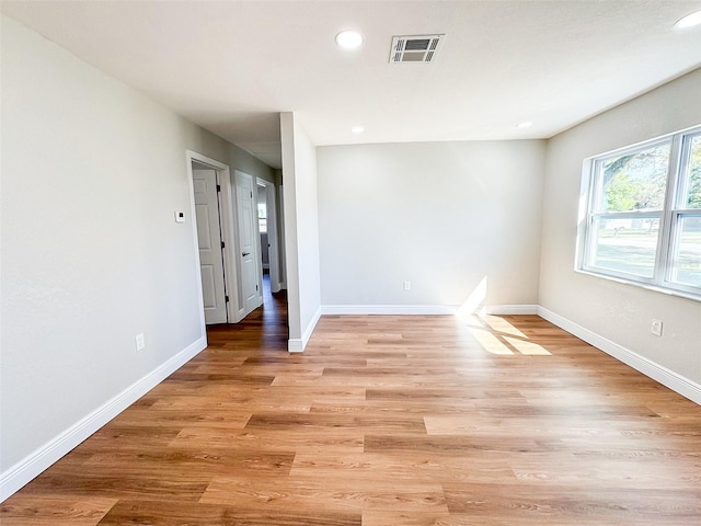 unfurnished room featuring light wood-style floors, baseboards, visible vents, and recessed lighting