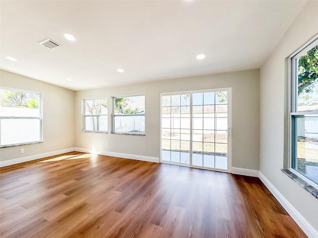 spare room with visible vents, baseboards, wood finished floors, and recessed lighting