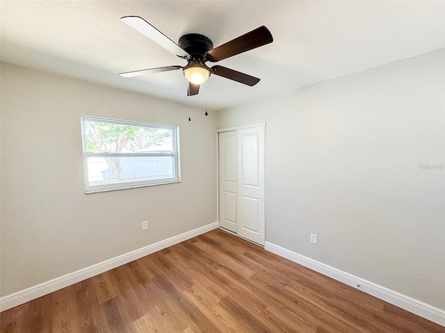 spare room with ceiling fan, wood finished floors, and baseboards