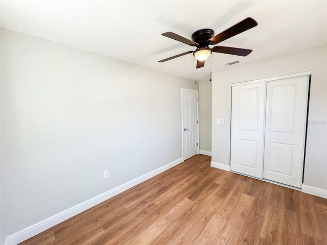 unfurnished bedroom featuring a closet, visible vents, a ceiling fan, light wood-type flooring, and baseboards