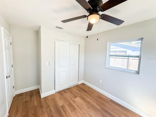 unfurnished bedroom with light wood-type flooring, visible vents, baseboards, and a closet