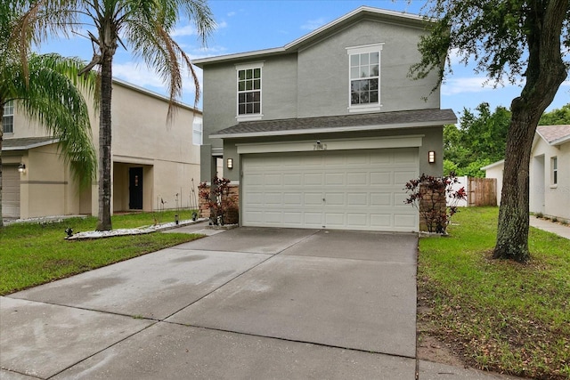 traditional home featuring a garage, driveway, a front lawn, and stucco siding