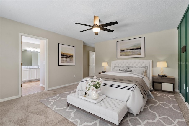 carpeted bedroom with visible vents, baseboards, a textured ceiling, and ensuite bathroom