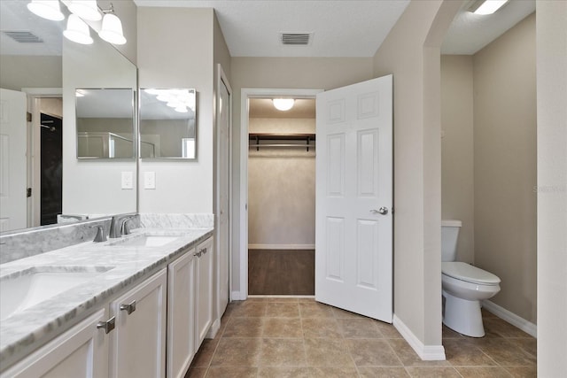 full bathroom featuring toilet, baseboards, visible vents, and a sink