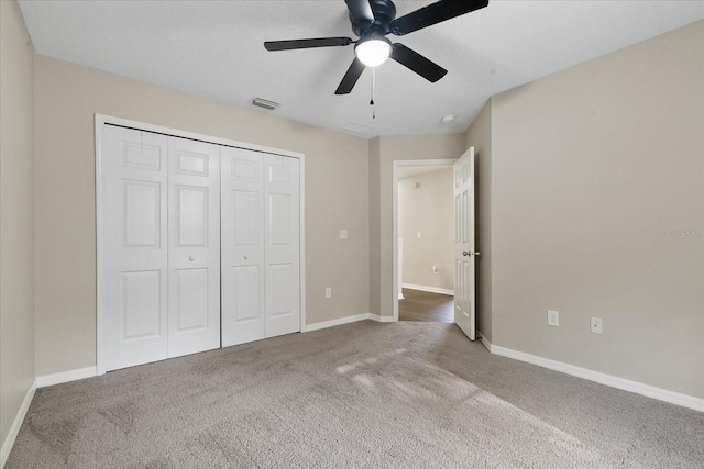 unfurnished bedroom featuring carpet floors, baseboards, visible vents, and a closet