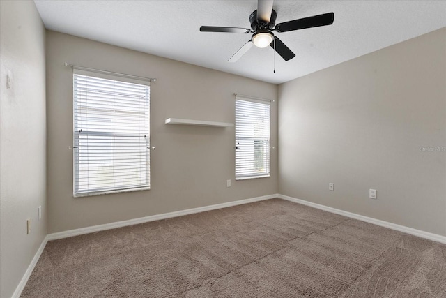 carpeted spare room featuring ceiling fan, baseboards, and a textured ceiling