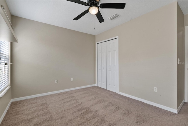 unfurnished bedroom with carpet floors, a closet, visible vents, and baseboards