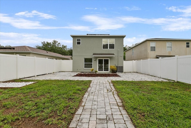 rear view of property featuring a lawn, a patio area, a fenced backyard, and central air condition unit