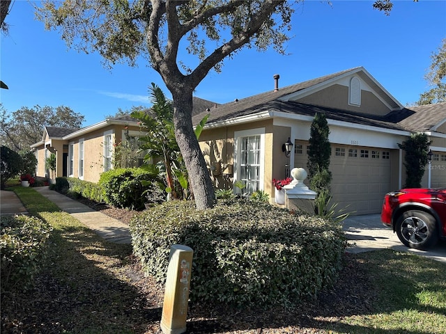 view of front of home featuring an attached garage, concrete driveway, and stucco siding