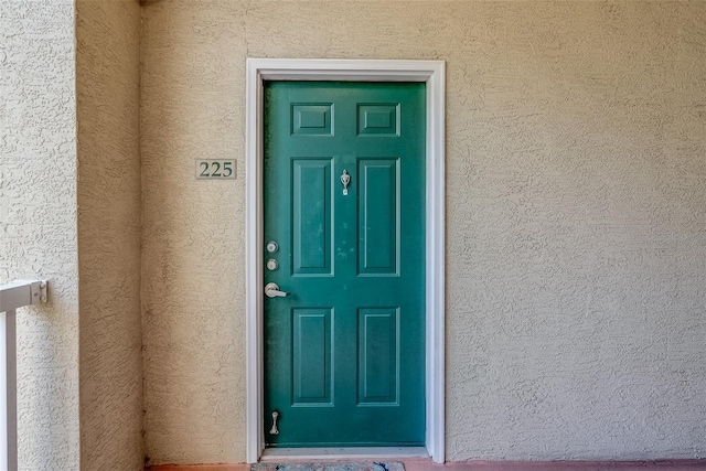 view of exterior entry with stucco siding