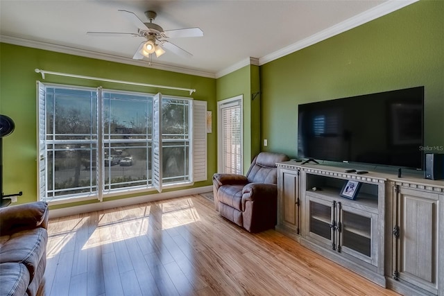 living area featuring wood finished floors, a ceiling fan, and crown molding