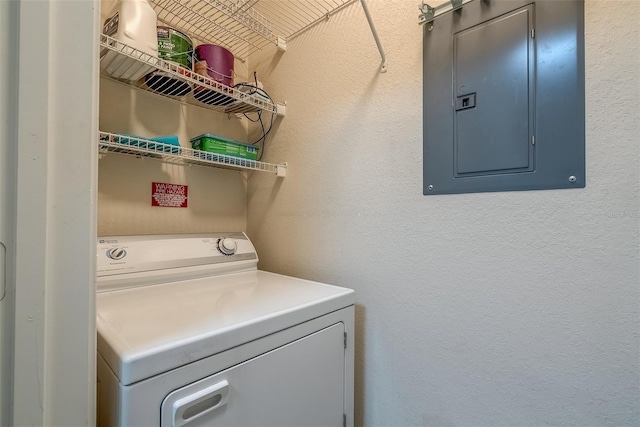 laundry room with a textured wall, washer / clothes dryer, and electric panel