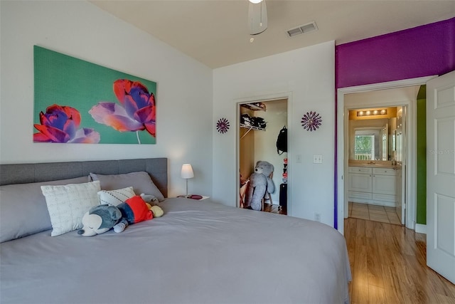 bedroom featuring a closet, visible vents, and wood finished floors