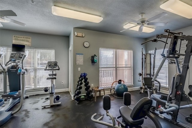 gym featuring ceiling fan, baseboards, and a textured ceiling