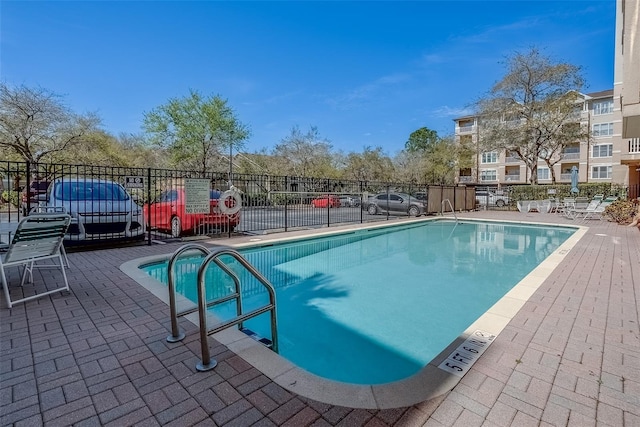 pool with fence and a patio