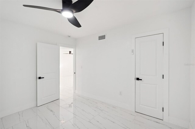 unfurnished bedroom with ceiling fan, marble finish floor, visible vents, and baseboards