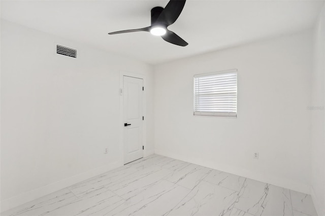 empty room featuring marble finish floor, ceiling fan, visible vents, and baseboards