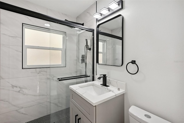 full bath featuring toilet, a marble finish shower, and vanity