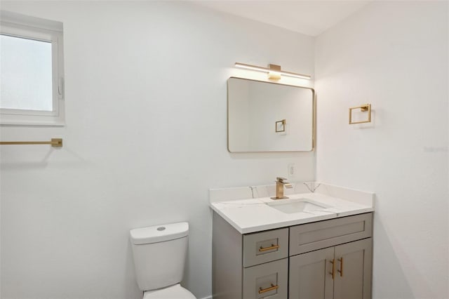 half bathroom featuring vanity and toilet