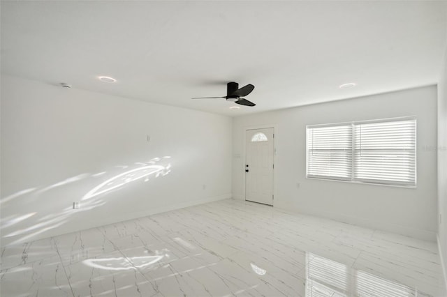 unfurnished room featuring ceiling fan and baseboards