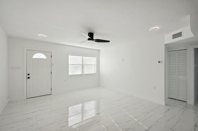 foyer entrance with ceiling fan, marble finish floor, visible vents, and baseboards