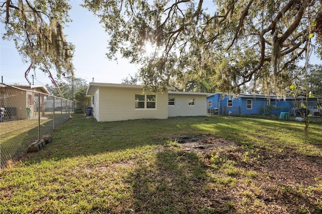 back of property with a yard and fence