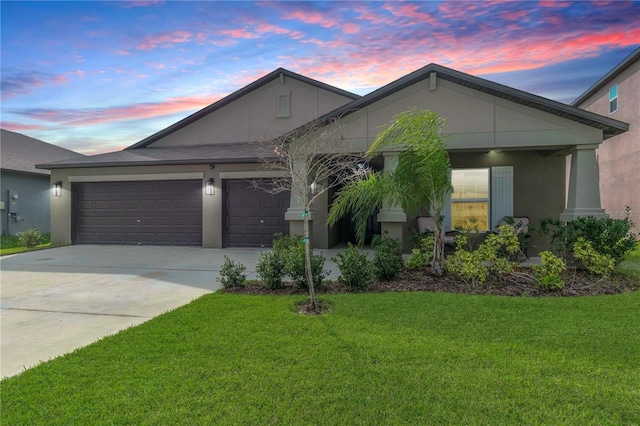 ranch-style house featuring a garage, a front yard, concrete driveway, and stucco siding