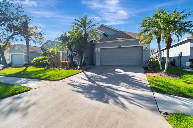 view of front of property with a garage, driveway, a front lawn, and stucco siding