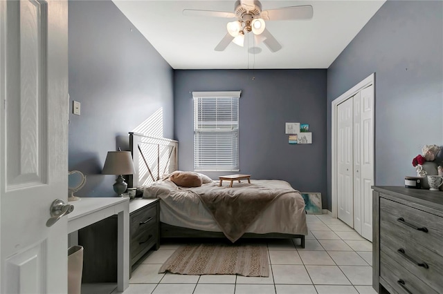 bedroom with light tile patterned floors, ceiling fan, and a closet