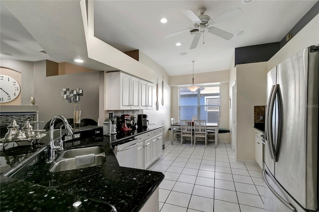 kitchen with light tile patterned floors, a sink, white cabinetry, appliances with stainless steel finishes, and decorative backsplash