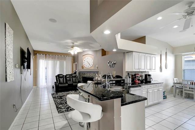 kitchen with a peninsula, ceiling fan, and light tile patterned flooring