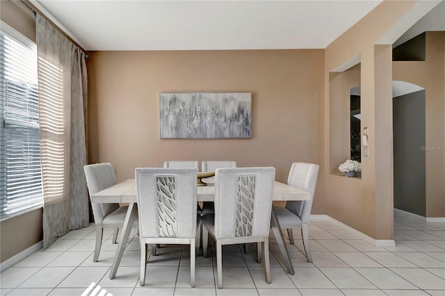 dining area featuring plenty of natural light, baseboards, and light tile patterned flooring