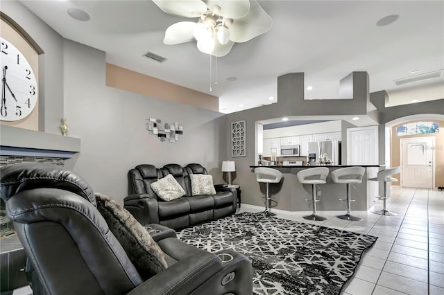 living area with light tile patterned floors, ceiling fan, and visible vents