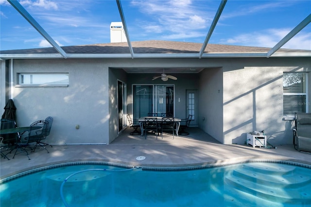 rear view of property featuring a lanai, a patio area, and stucco siding