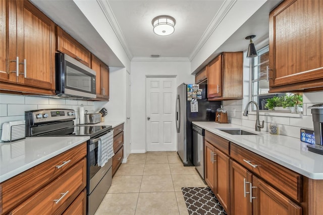 kitchen with a sink, stainless steel appliances, brown cabinets, and crown molding