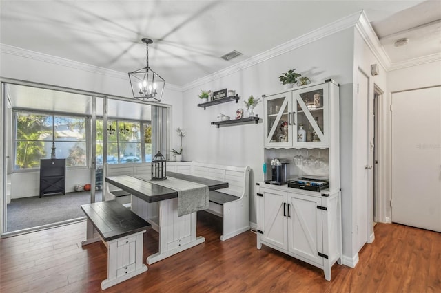 kitchen with an inviting chandelier, dark wood-type flooring, white cabinets, glass insert cabinets, and crown molding