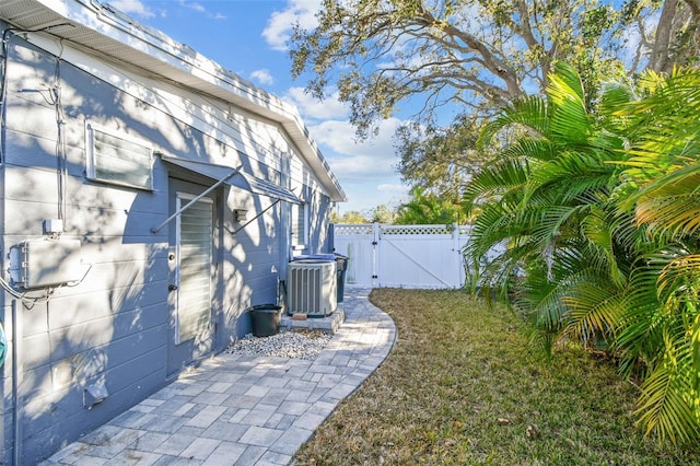 view of yard with central air condition unit, a gate, and fence