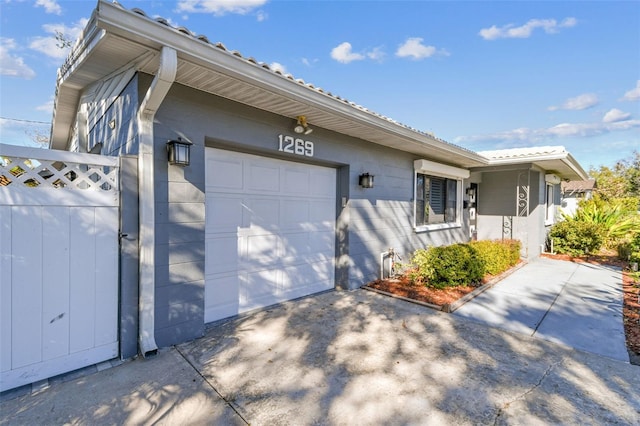 view of front of home featuring an attached garage, fence, and driveway