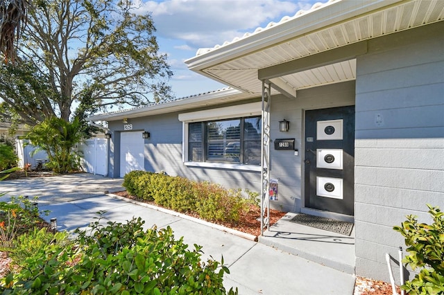 view of exterior entry featuring concrete driveway and a garage